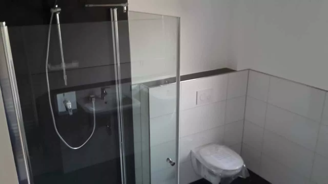 Dusche mit Glasabtrennung und wandhängendem WC